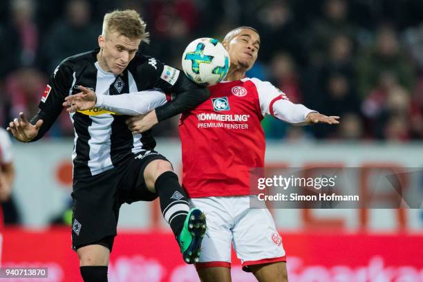 Oscar Wendt of Moenchengladbach jumps for a header with Robin Quaison of Mainz during the Bundesliga match between 1. FSV Mainz 05 and Borussia...