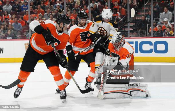 Petr Mrazek of the Philadelphia Flyers pins the loose puck to his chest as Jori Lehtera and Andrew MacDonald defend against the attack of Tim...
