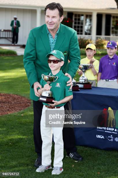 Sir Nick Faldo presents Luke Parsons, participant in the 7-9 boys, with his trophy during the Drive, Chip and Putt Championship at Augusta National...