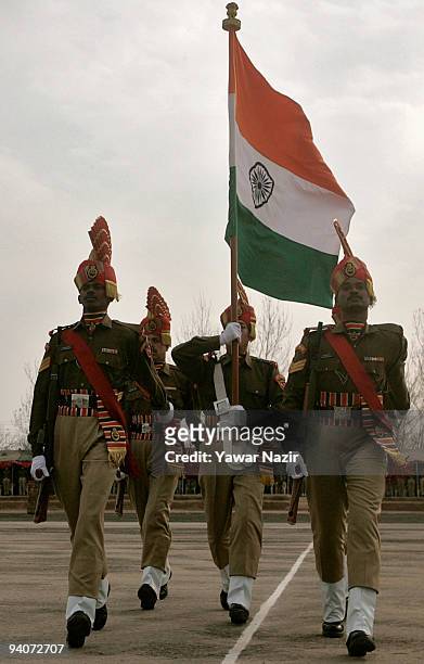 Indian Border Security Force soldiers hold Indian flag as they march during their passing out parade on December 06, 2009 in Humhama, on the...