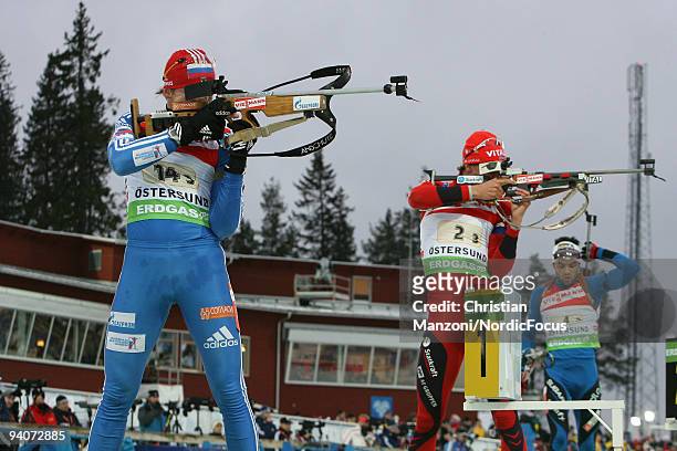 Victor Vasilyev of Russia, Lars Berger of Norway and Simon Fourcade of France at the shooting range during the Men's 4x7.5 km Relay in the E.ON...