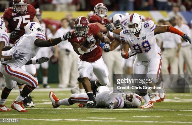 Mark Ingram of the Alabama Crimson Tide runs the ball against Omar Hunter of the Florida Gators during the SEC Championship game at Georgia Dome on...