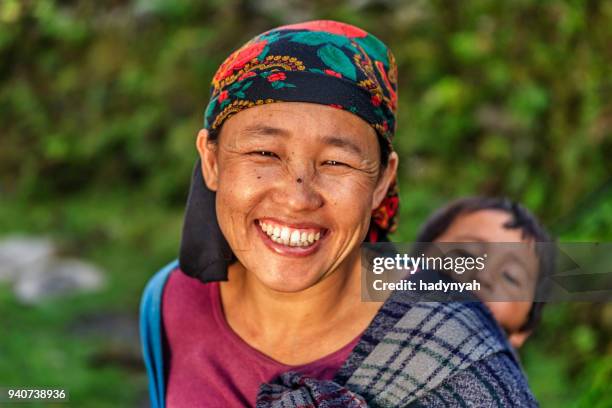 nepalesische frau mit ihrem baby in der nähe von annapurna range - nepali mother stock-fotos und bilder