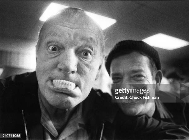 Two men make funny faces using dentures while in Ole Joe Poe's Tavern in New Athens, Illinois, 1976.