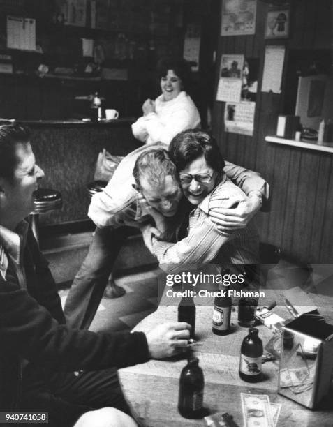 Friends hugging and joking in Ole Joe Poe's Tavern in New Athens, Illinois, 1976.