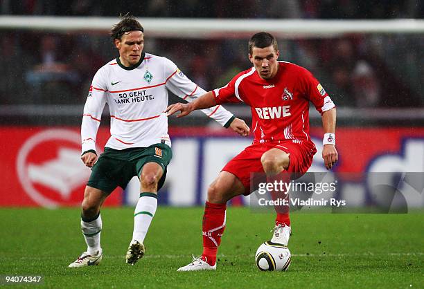 Lukas Podolski of Koeln and Clemens Fritz of Bremen in action during the Bundesliga match between 1. FC Koeln and SV Werder Bremen at RheinEnergie...