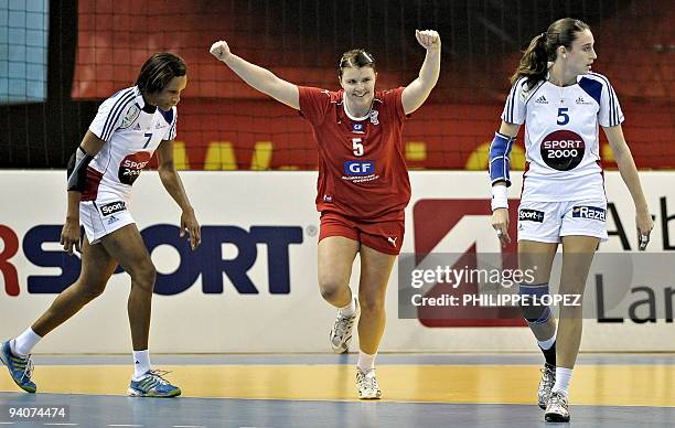 Denmark's Mie Augustesen reacts after scoring as she runs past France's Allison Pineau and Camille Ayglon during the preliminary round match between...