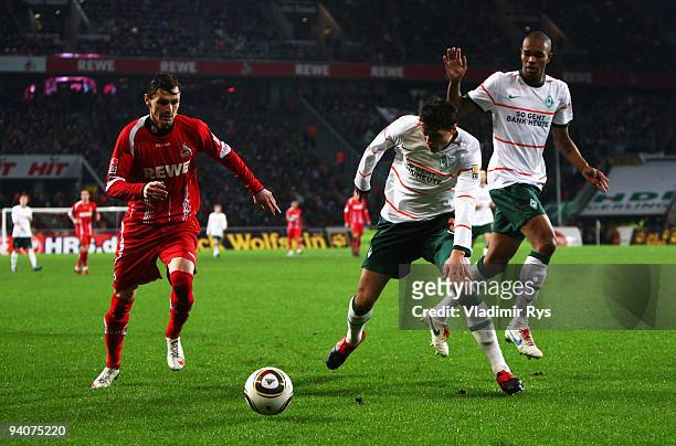 Milivoje Novakovic of Koeln is defended by Sebastian Boenisch and Naldo of Bremen during the Bundesliga match between 1. FC Koeln and SV Werder...