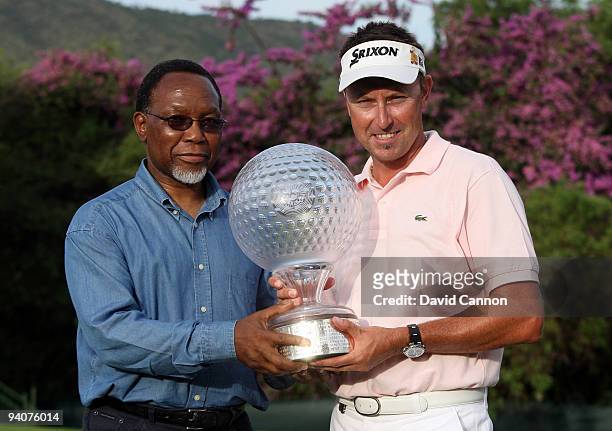 Robert Allenby of Australia is presented with the trophy by the Vice-President of South Africa, Kgalema Motlanthe, after the final round of the...