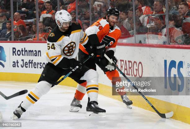 Sean Couturier of the Philadelphia Flyers battles along the boards with Adam McQuaid of the Boston Bruins on April 1, 2018 at the Wells Fargo Center...