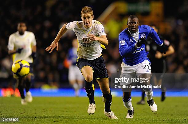 Michael Dawson of Tottenham Hotspur competes for the ball with Yakubu of Everton during the Barclays Premier League match between Everton and...