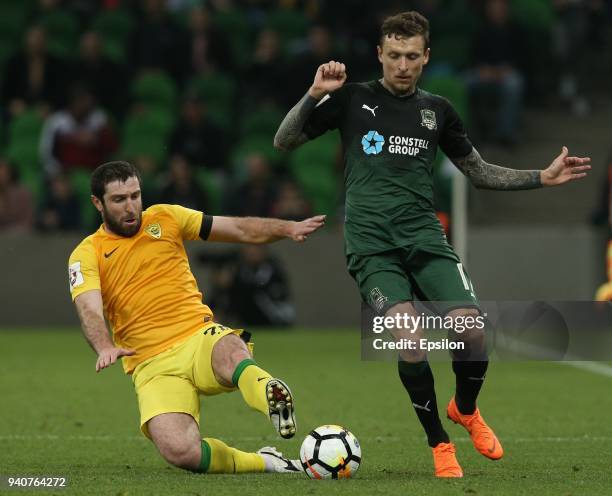 Pavel Mamayev of FC Krasnodar vies for the ball with Mikhail Bakayev of FC Anzhi Makhachkala during the Russian Premier League match between FC...