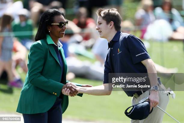 Corey Boerner, participant in the boys 14-15, shakes hands with Condoleezza Rice during the Drive, Chip and Putt Championship at Augusta National...