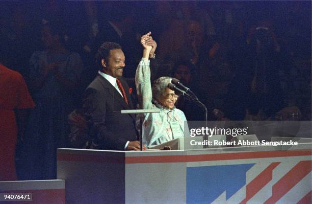 Democratic presidential candidate Reverend Jesse Jackson raising linked hands with civil rights pioneer Rosa Parks during the Democratic National...