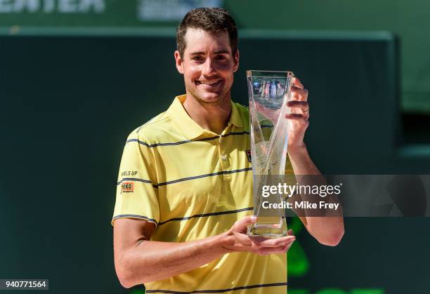 April 01: John Isner of the USA poses with the trophy after beating Alexander Zverev of Germany 6-7 6-4 6-4 in the men's final on Day 14 of the Miami...