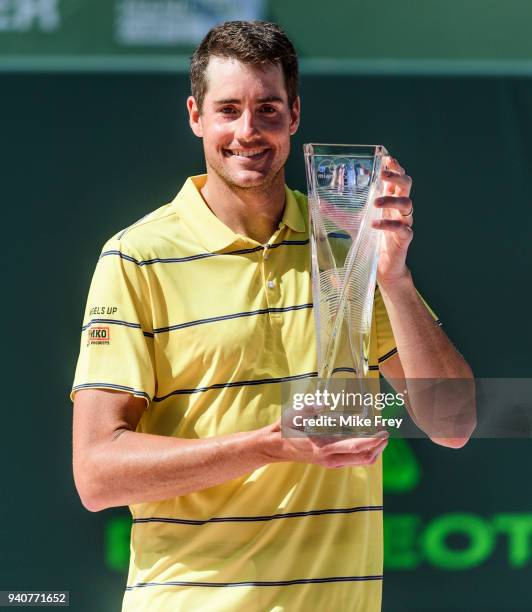 April 01: John Isner of the USA poses with the trophy after beating Alexander Zverev of Germany 6-7 6-4 6-4 in the men's final on Day 14 of the Miami...