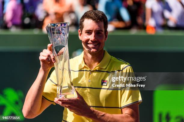 April 01: John Isner of the USA poses with the trophy after beating Alexander Zverev of Germany 6-7 6-4 6-4 in the men's final on Day 14 of the Miami...