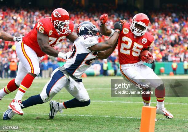 Running back Jamal Charles of the Kansas City Chiefs tries to turn the corner as safety Brian Dawkins of the Denver Broncos defends during the game...