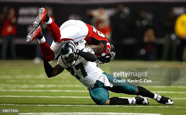 Quintin Mikell of the Philadelphia Eagles upends Jerious Norwood of the Atlanta Falcons at the Georgia Dome on December 6, 2009 in Atlanta, Georgia.