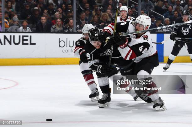 Alex Iafallo of the Los Angeles Kings battles for the puck against Jordan Martinook and Jakob Chychrun of the Arizona Coyotes during the game on...