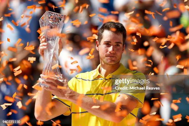 John Isner of the United States poses for a photo with the Butch Buchholz Trophy after defeating Alexander Zverev of Germany in the men's final on...