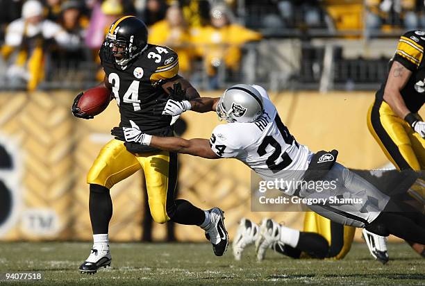 Rashard Mendenhall of the Pittsburgh Steelers tries to get around the tackle of Michael Huff the Oakland Raiders during a first quarter run on...