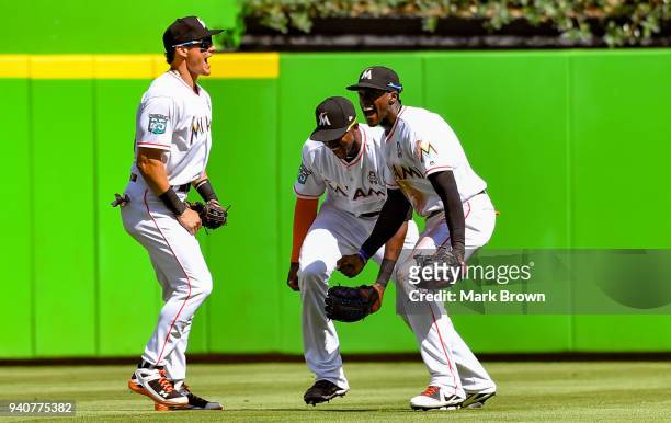 Derek Dietrich, Lewis Brinson and Cameron Maybin of the Miami Marlins celebrate after the game against the Chicago Cubs at Marlins Park on April 1,...