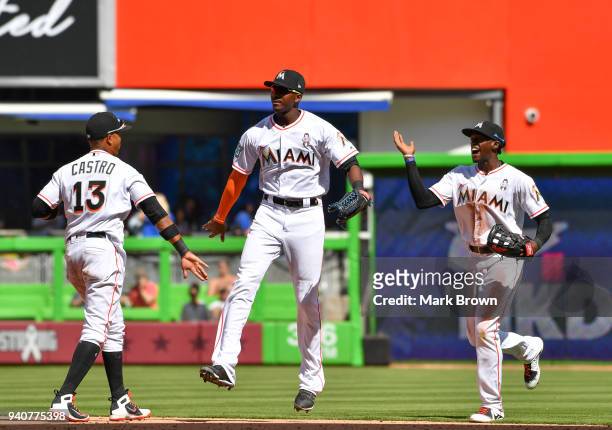 Starlin Castro , Lewis Brinson and Cameron Maybin of the Miami Marlins celebrate after the game against the Chicago Cubs at Marlins Park on April 1,...