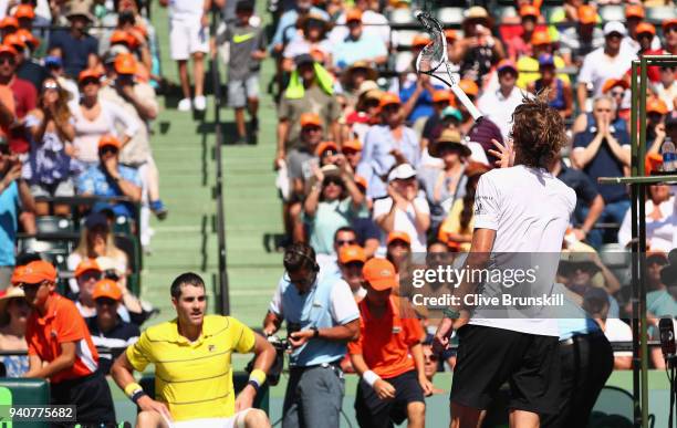 Alexander Zverev of Germany throws his racket to the crowd after smashing it upon his serve being broken in the third set against John Isner of the...