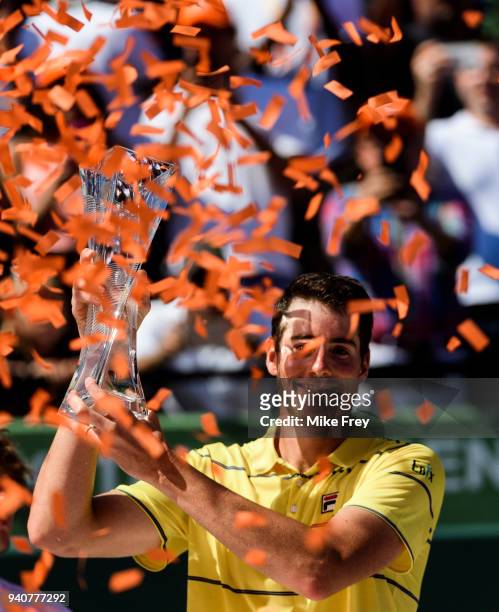 April 01: John Isner of the USA poses with the trophy after beating Alexander Zverev of Germany 6-7 6-4 6-4 in the men's final on Day 14 of the Miami...