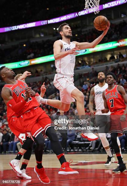 Tomas Satoransky of the Washington Wizards drives to the basket over David Nwaba of the Chicago Bulls at the United Center on April 1, 2018 in...