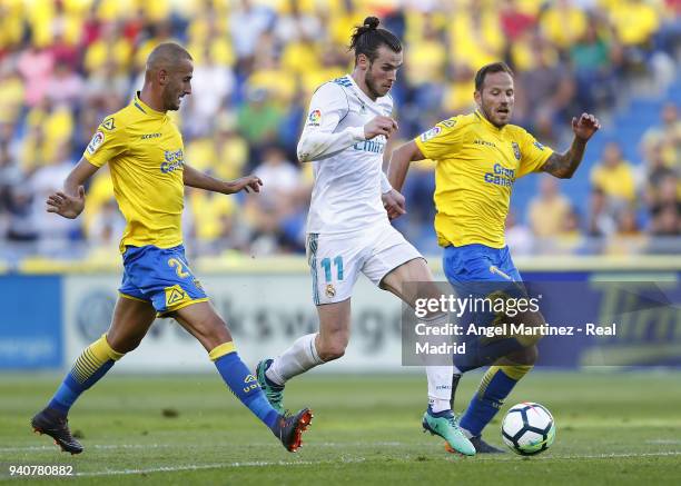 Gareth Bale of Real Madrid competes for the ball with Javi Castellano and Alejandro Galvez of UD Las Palmas during the La Liga match between UD Las...