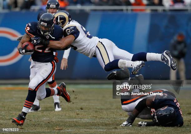 Paris Lenon of the St. Louis Rams leaps over Frank Omiyale of the Chicago Bears to try and tackle Matt Forte at Soldier Field on December 6, 2009 in...