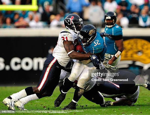 Maurice Jones-Drew of the Jacksonville Jaguars is tackled by Bernard Pollard of the Houston Texans during the game at Jacksonville Municipal Stadium...