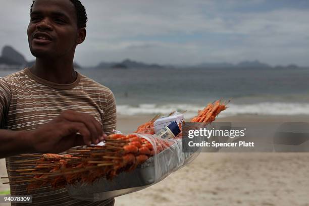 Teenager sells shrimp at the beach December 6, 2009 in Rio de Janeiro, Brazil. The beach is an interregnal part of life for residents of Rio....