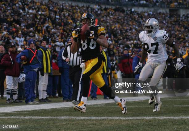 Hines Ward of the Pittsburgh Steelers catches a touchdown pass in the fourth quarter in front of Chris Johnson of the Oakland Raiders during the game...