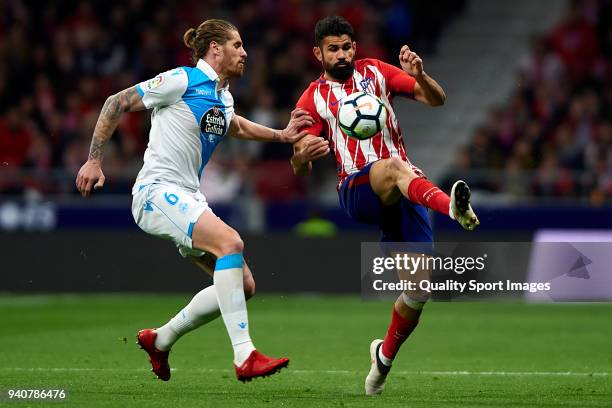 Diego Costa of Atletico de Madrid competes for the ball with Raul Albentosa of Deportivo La Coruna during the La Liga match between Atletico Madrid...