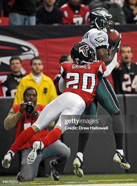 Wide receiver Reggie Brown of the Philadelphia Eagles catches a pass while getting hit by cornerback Brent Grimes of the Atlanta Falcons on December...