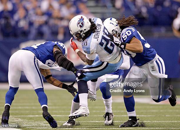 Chris Johnson of the Tennessee Titans is tackled by Antoine Bethea and Philip Weaver of the Indianapolis Colts at Lucas Oil Stadium on December 6,...