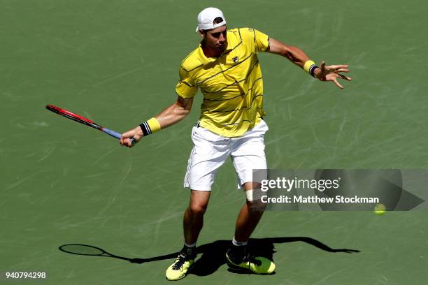 John Isner returns a shot to Alexander Zverev of German during the men's final of the Miami Open Presented by Itau at Crandon Park Tennis Center on...