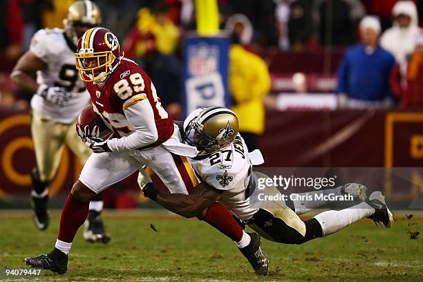 Santana Moss of the Washington Redskins is tackled by makes a break past Malcolm Jenkins of the New Orleans Saints on December 6, 2009 at FedExField...