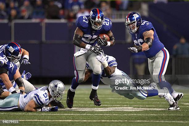 Brandon Jacobs of the New York Giants runs the ball in the first half against DeMarcus Ware and Keith Brooking of the Dallas Cowboys at Giants...