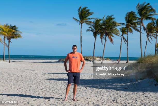 John Isner of the USA poses on Crandon Park Beach with the trophy after beating Alexander Zverev of Germany 6-7 6-4 6-4 in the men's final on Day 14...