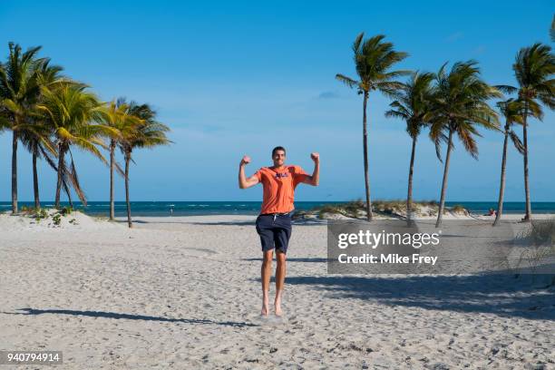 John Isner of the USA poses on Crandon Park Beach with the trophy after beating Alexander Zverev of Germany 6-7 6-4 6-4 in the men's final on Day 14...