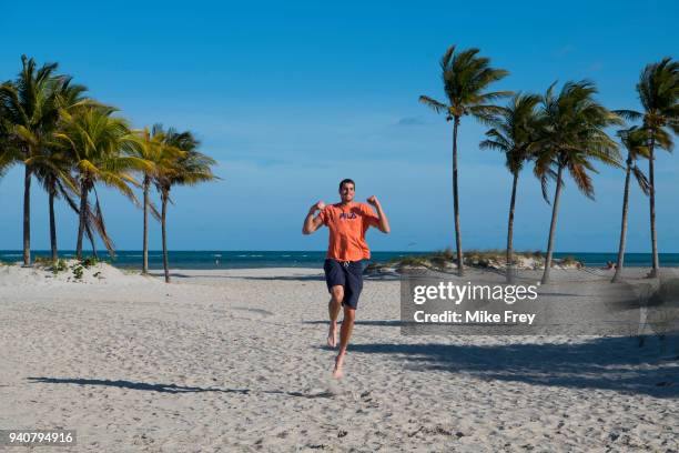 John Isner of the USA poses on Crandon Park Beach with the trophy after beating Alexander Zverev of Germany 6-7 6-4 6-4 in the men's final on Day 14...