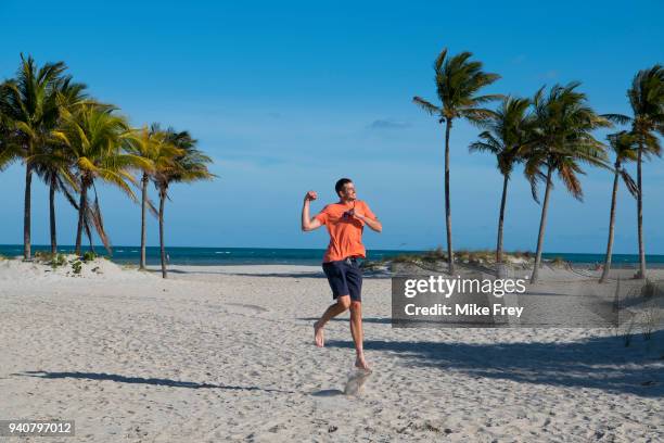 John Isner of the USA poses on Crandon Park Beach with the trophy after beating Alexander Zverev of Germany 6-7 6-4 6-4 in the men's final on Day 14...