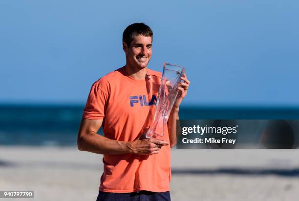 John Isner of the USA poses on Crandon Park Beach with the trophy after beating Alexander Zverev of Germany 6-7 6-4 6-4 in the men's final on Day 14...