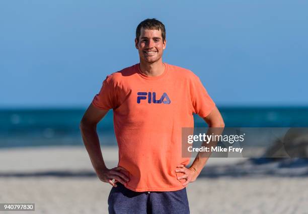 John Isner of the USA poses on Crandon Park Beach with the trophy after beating Alexander Zverev of Germany 6-7 6-4 6-4 in the men's final on Day 14...