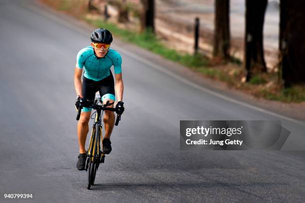 cyclist riding a bicycle in  bike lane - asian championship stock pictures, royalty-free photos & images