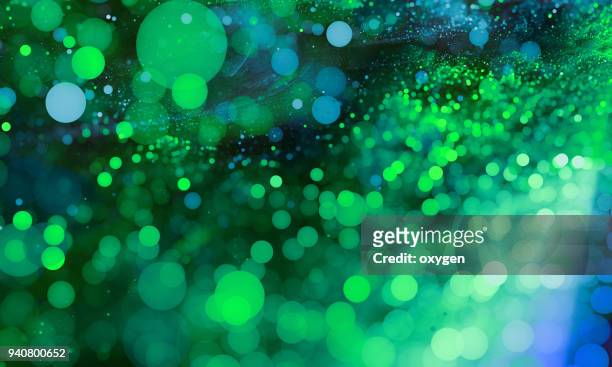 abstract green bokeh sparkling spray circle - hintergrund grün und licht verschwommen stock-fotos und bilder